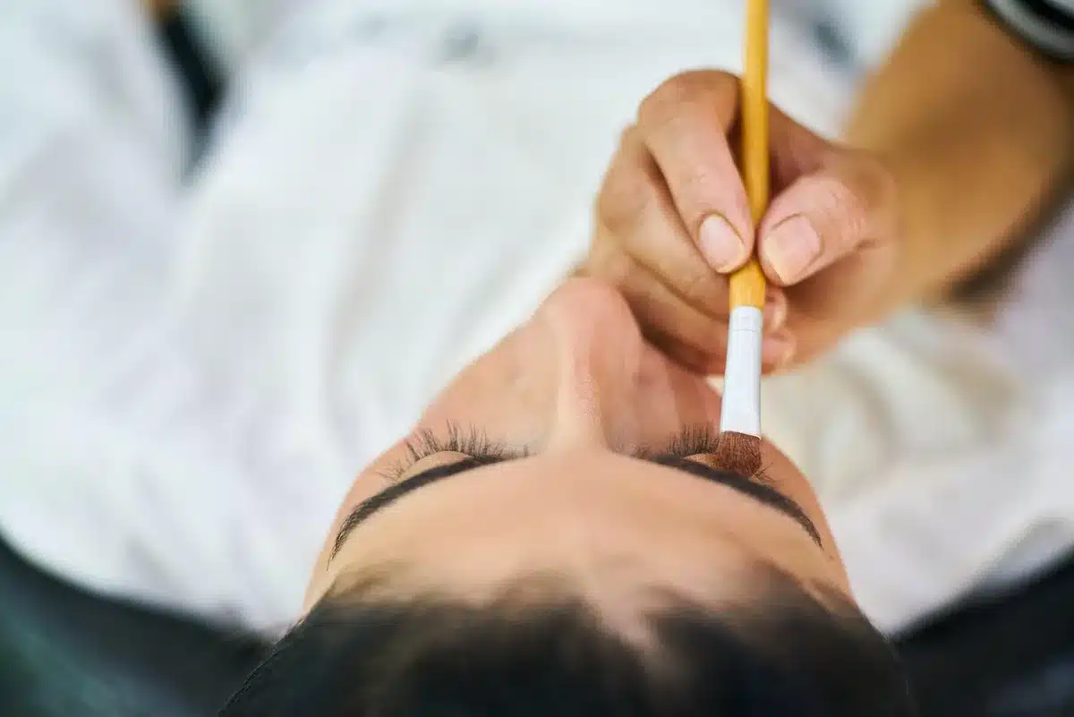 Primo piano su mani che tracciano un look narrativo su un volto neutro
