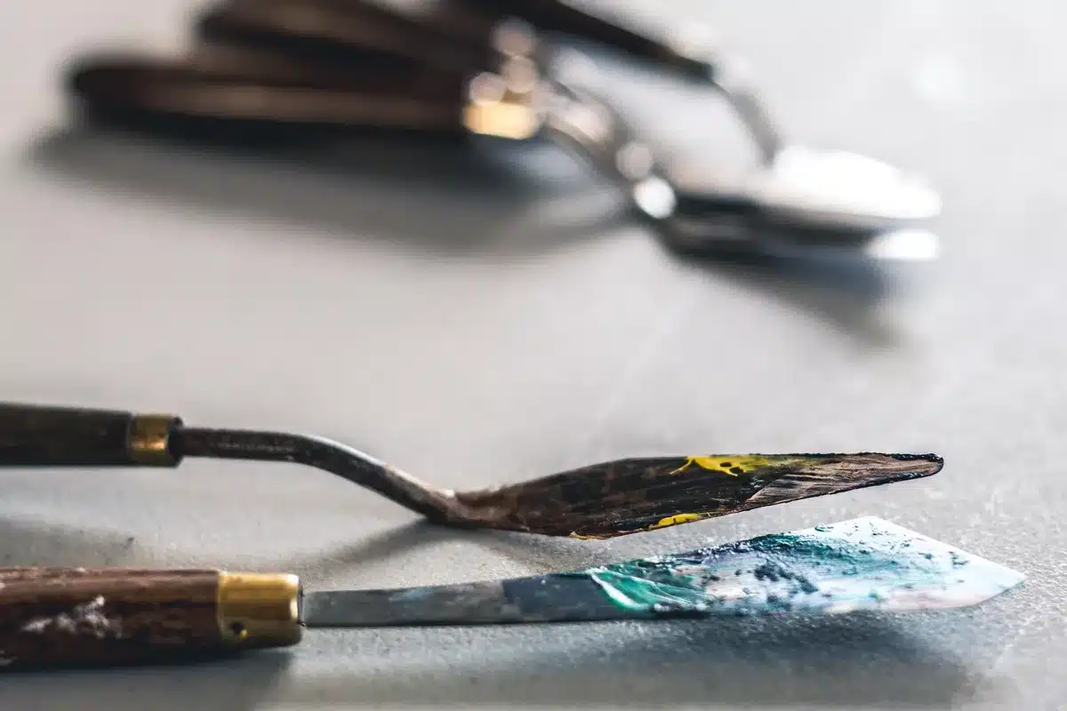 Mani anonime che lavorano su palette e prodotti make‑up in un backstage