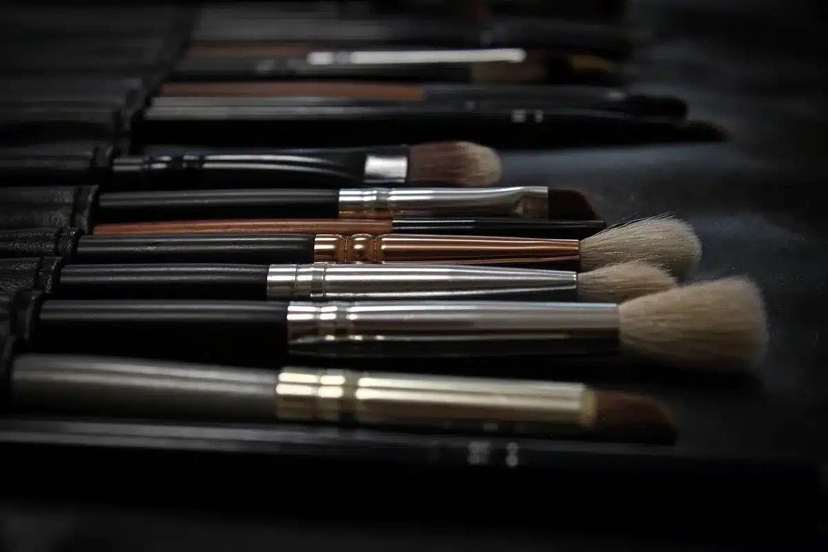 Makeup artist che ritocca il trucco di un'attrice durante una pausa sul red carpet