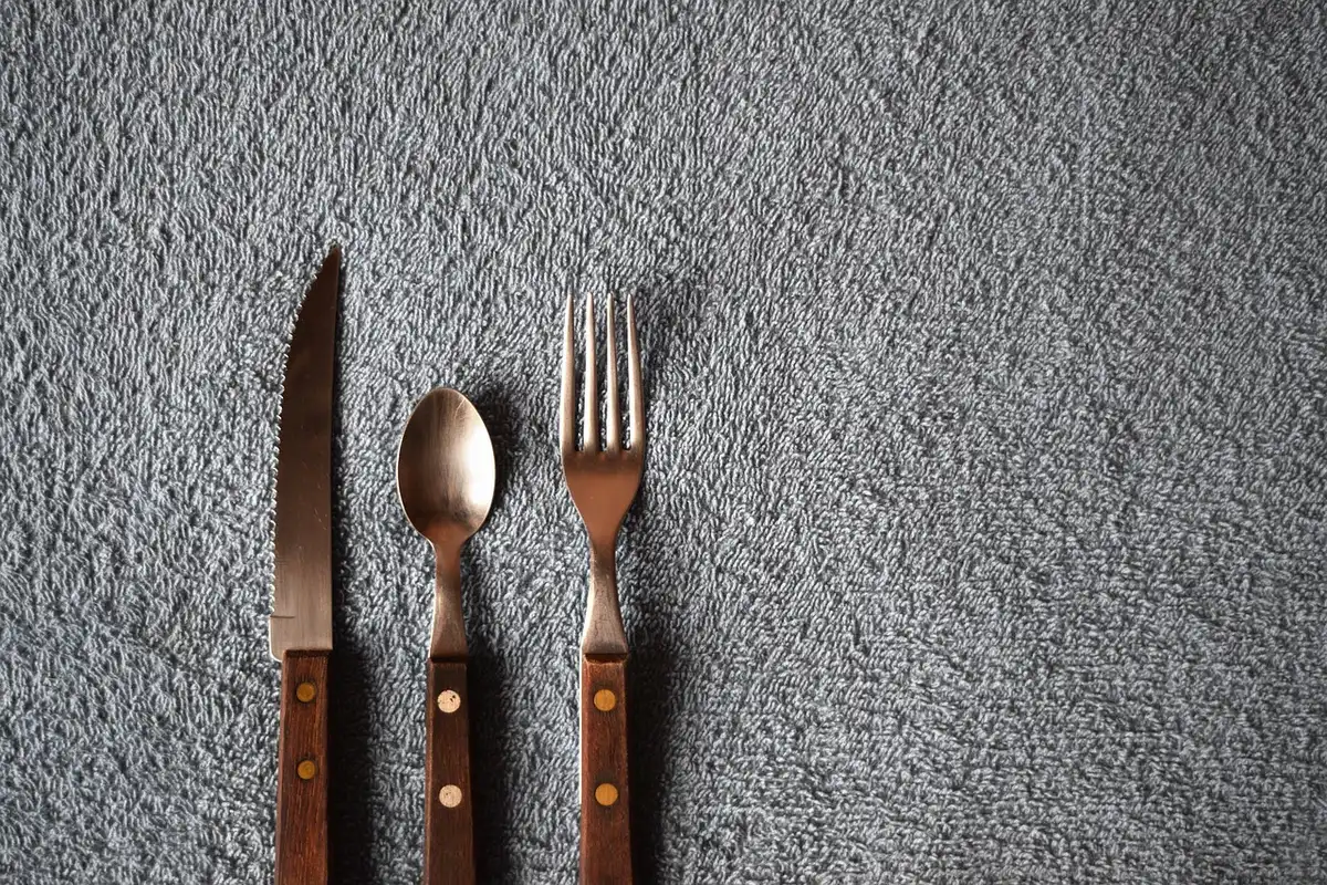 Un coltello da cucina e una cintura su un tavolo, simbolo degli oggetti citati nella denuncia