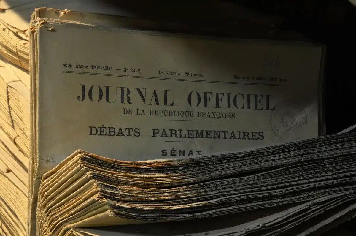 Mani che sfogliano pagine ingiallite di giornali storici in una biblioteca