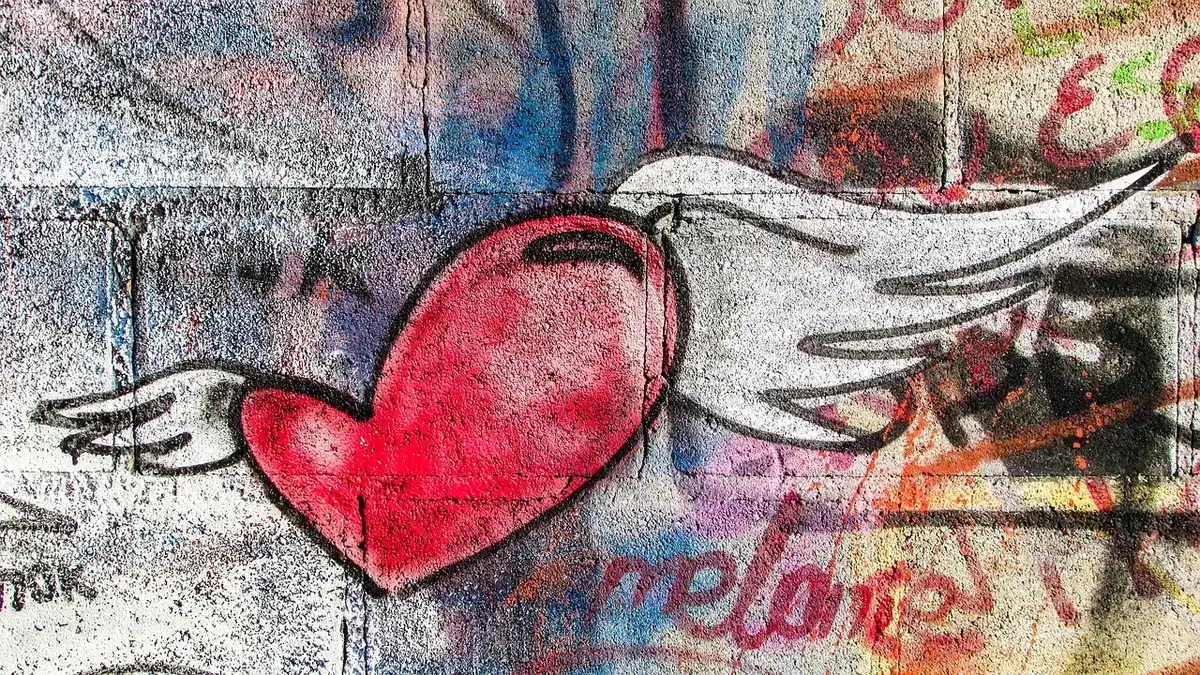 Visitatori davanti a un muro digitale che simula graffiti con bombolette elettroniche