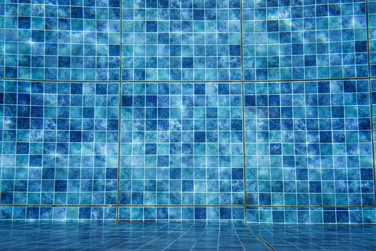 Tecnico controlla la pompa di un pozzetto di drenaggio per piscina