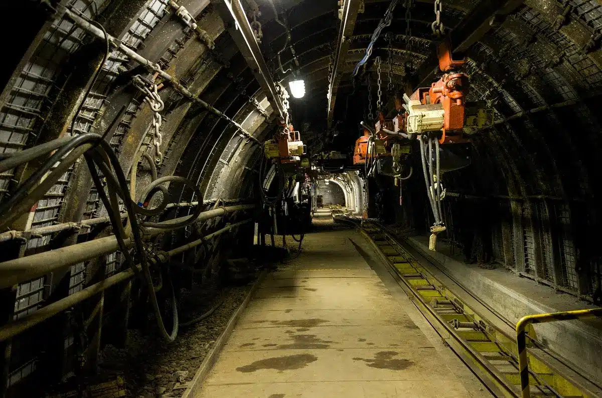 Trenino interno che scende nella galleria della miniera con pareti rocciose umide