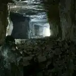 Galleria sotterranea di una miniera con pareti rocciose e umidità, ambiente terapeutico sotto la montagna