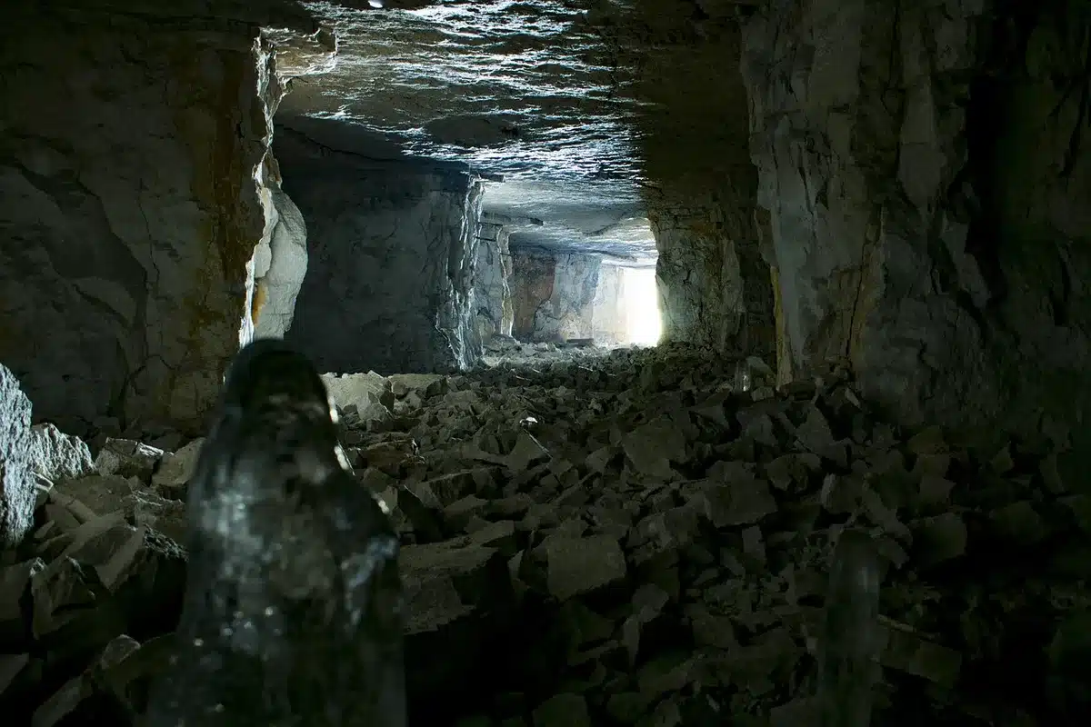 Galleria sotterranea di una miniera con pareti rocciose e umidità, ambiente terapeutico sotto la montagna