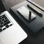 Silhouette di giornalisti in una redazione con scrivanie e microfoni, atmosfera di accoglienza