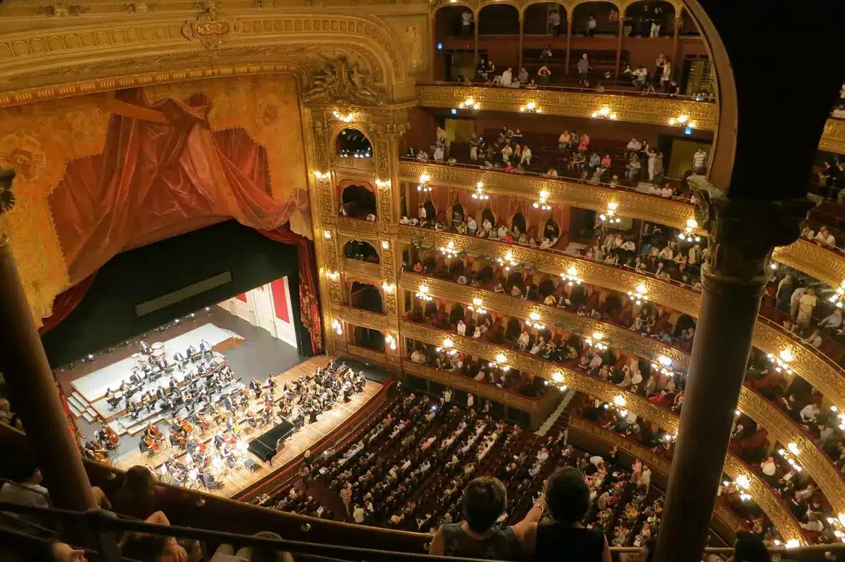 Persone che prenotano posti online davanti a un computer per il Teatro Verdi