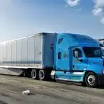 Area di rifornimento con camion e pompe di carburante al crepuscolo, prezzo sfocato