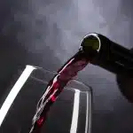 Chiazza oleosa che si diffonde lungo un canale d'acqua con barriere di contenimento e operazioni di soccorso