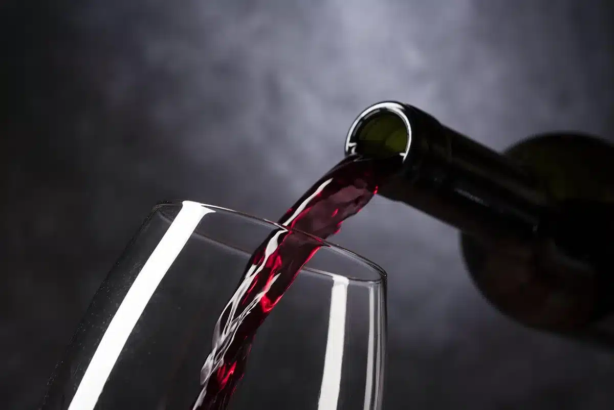 Chiazza oleosa che si diffonde lungo un canale d'acqua con barriere di contenimento e operazioni di soccorso