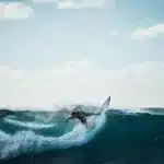 Persona che salta su un mini trampolino elastico in spiaggia durante l'estate