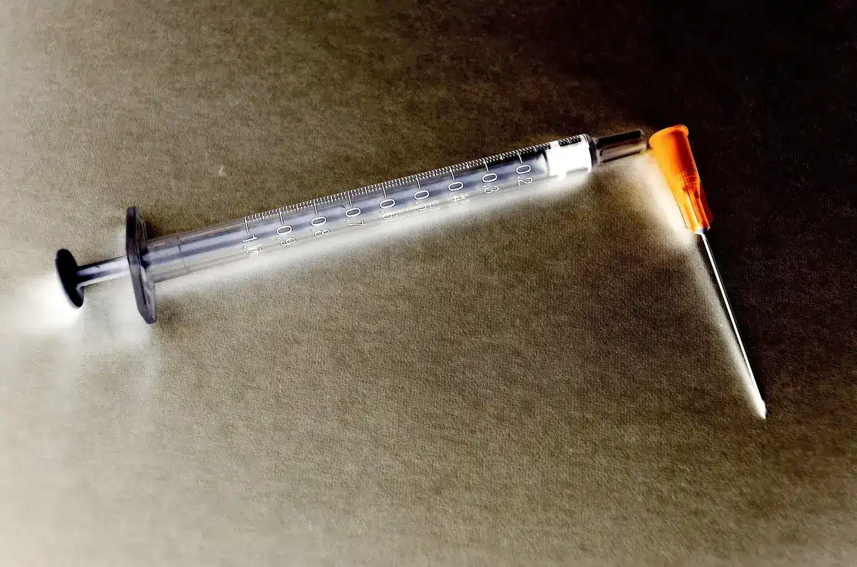 Dettaglio anonimo di una siringa e strumenti da studio estetico su un vassoio sterile