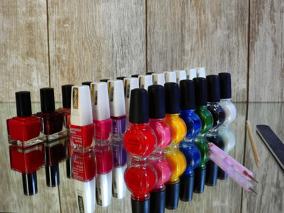 Unghie rosse con glitter dorati in primo piano