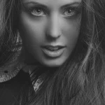 Donna di profilo con caschetto corto illuminato da luce studio in ambiente minimalista