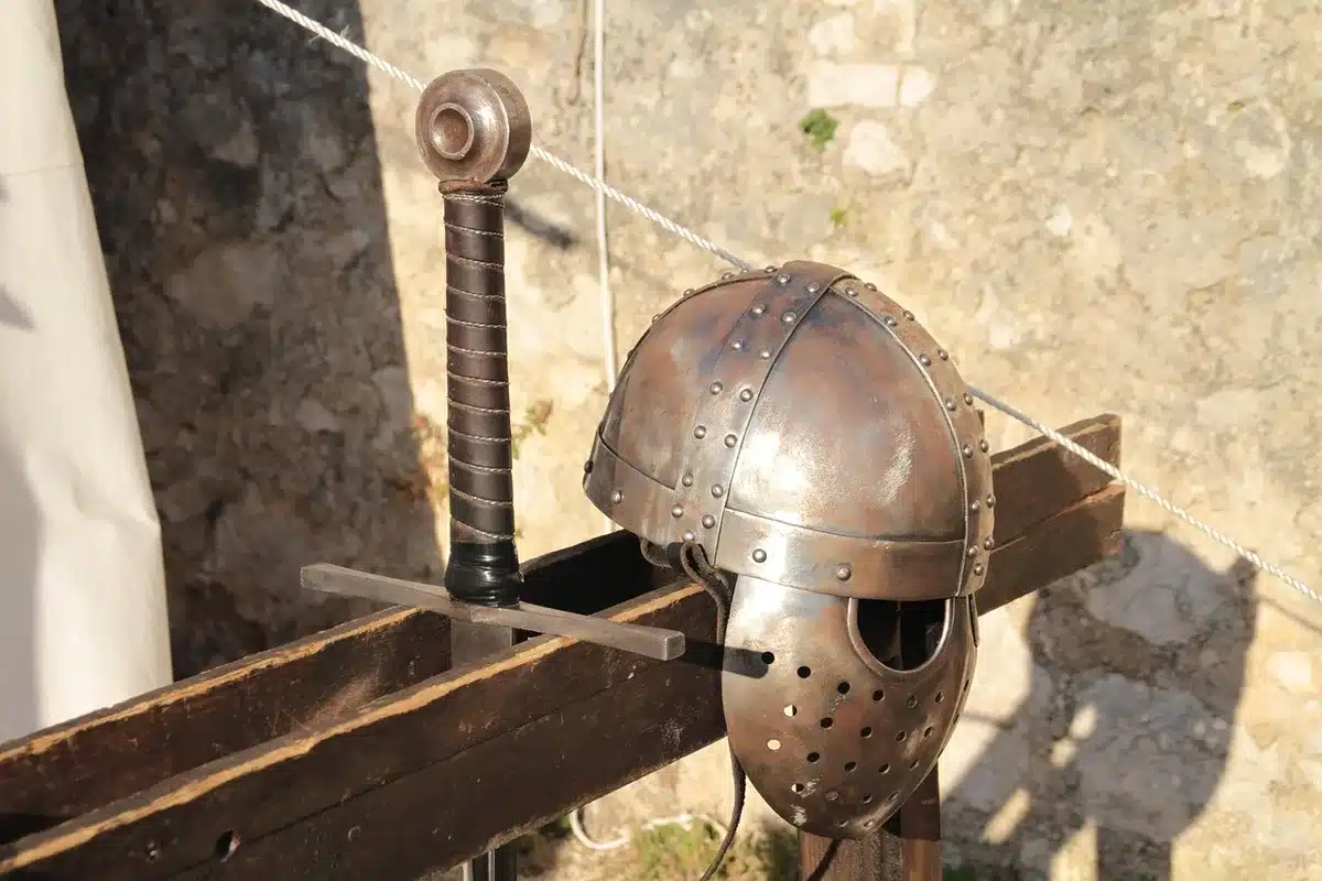 Fiera medievale con bancarelle storiche e figuranti in costumi d'epoca in un borgo antico.