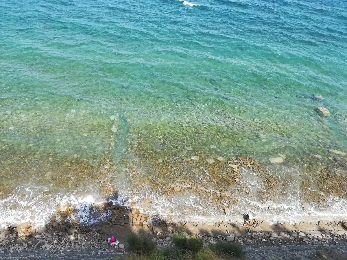 Tramonto dorato sulla costa adriatica delle Marche con figure silhouettate in spiaggia