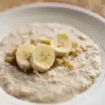 Colazione estiva con yogurt, frutta fresca e acqua su tavolo illuminato dal sole