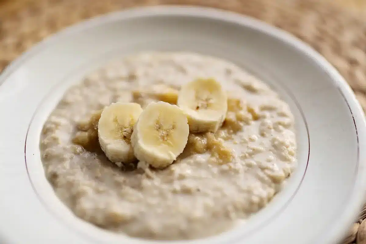 Colazione estiva con yogurt, frutta fresca e acqua su tavolo illuminato dal sole
