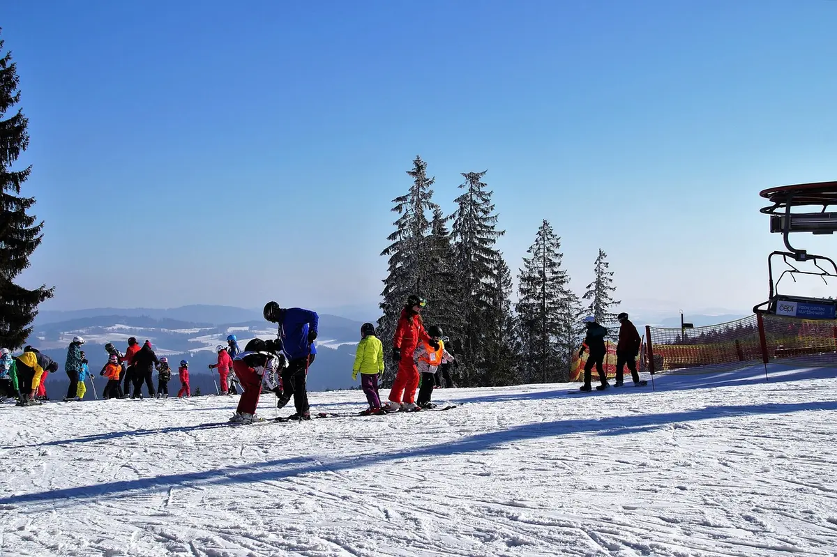 Parka e pantaloni da sci con stivali su un pendio nevoso