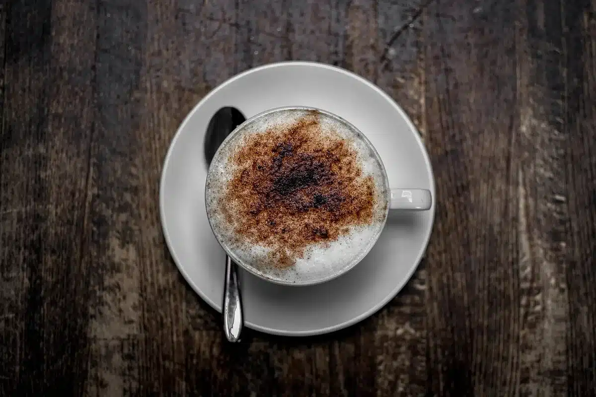 Tazzina di caffè su bancone con scontrino e contatori luce