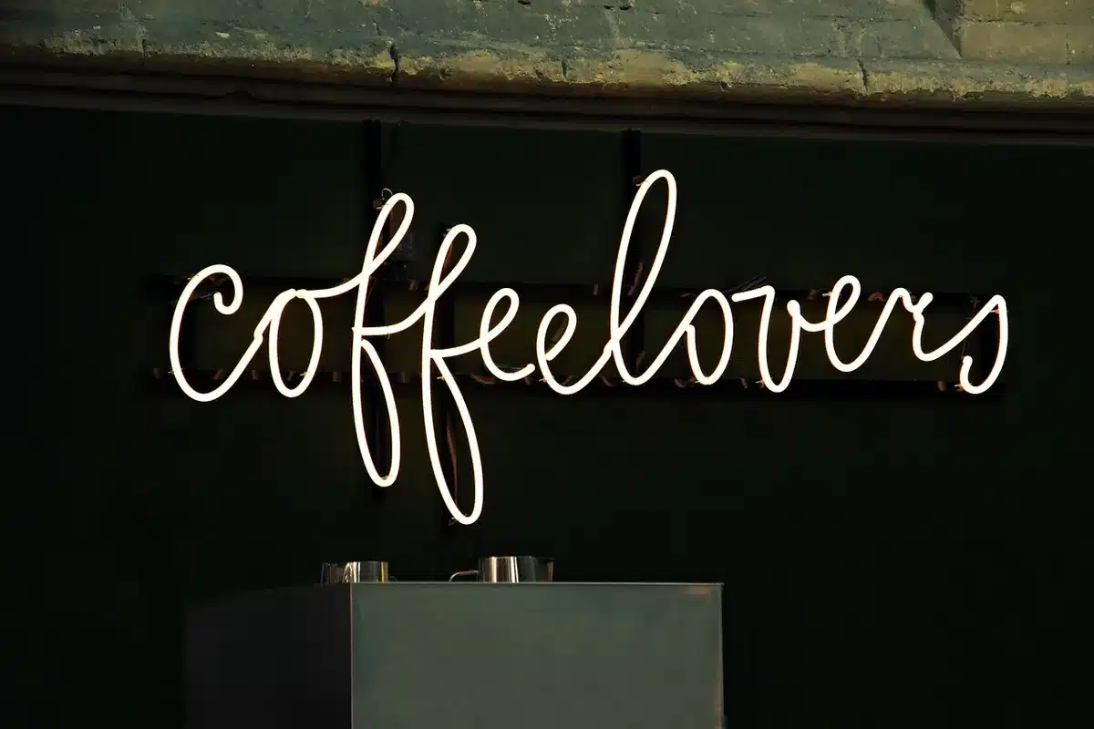 Interno di una caffetteria con tavoli, dolci artigianali e macchina del caffè specialty
