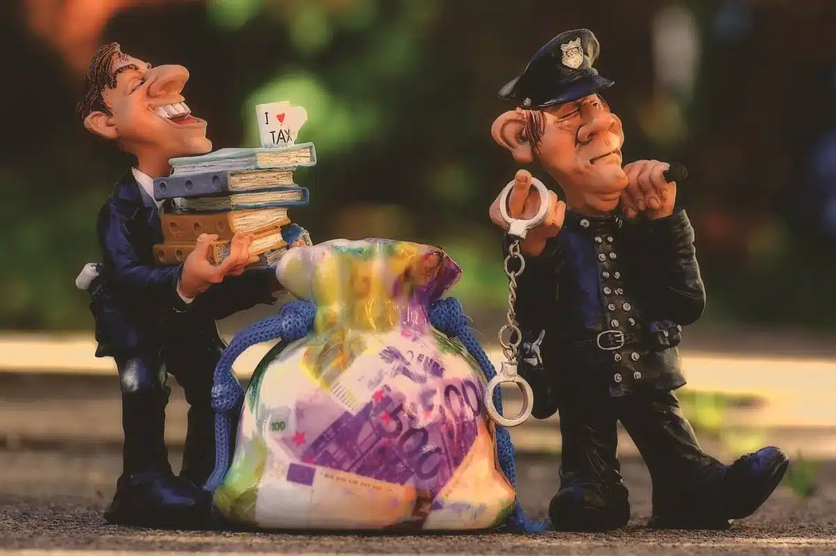 Monete e una pompa di benzina in miniatura per rappresentare lo sconto sulle accise
