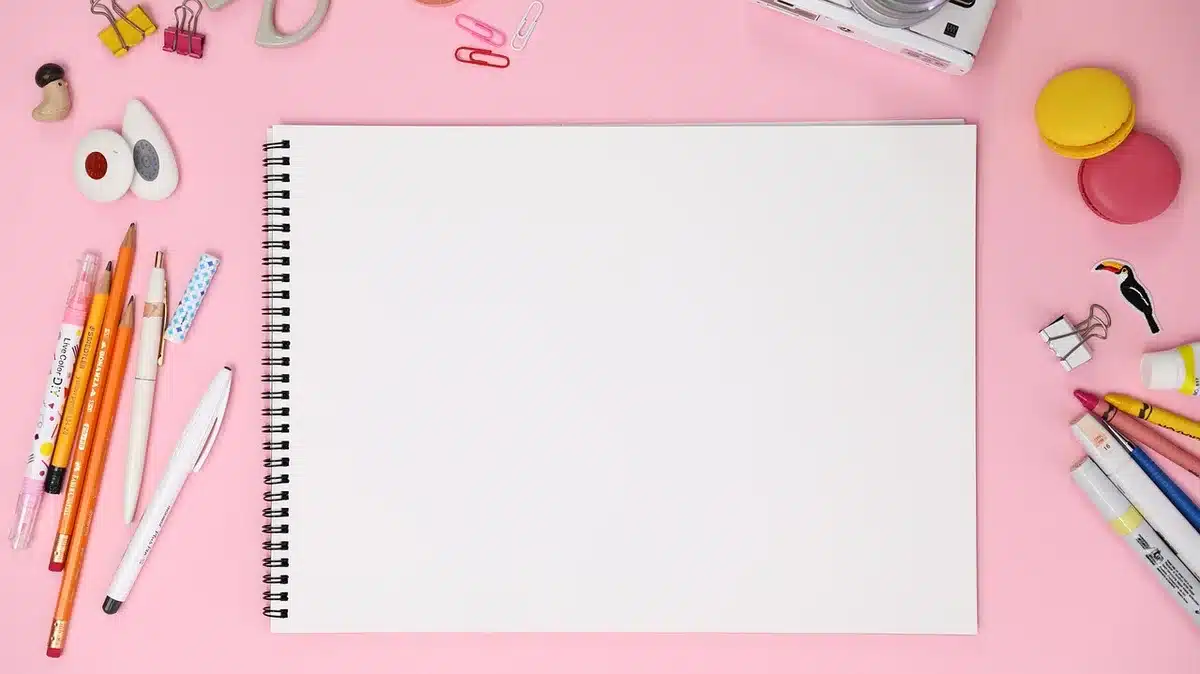Taccuino di disegno e materiali da moda su una scrivania