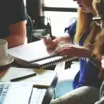 Laptop con codice HTML su scrivania redazione, tazza di caffè e taccuino