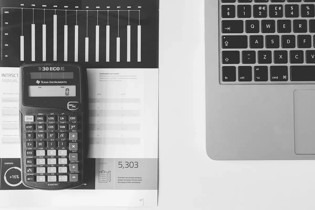 Mani anonime su documenti finanziari e calcolatrice in un ufficio luminoso
