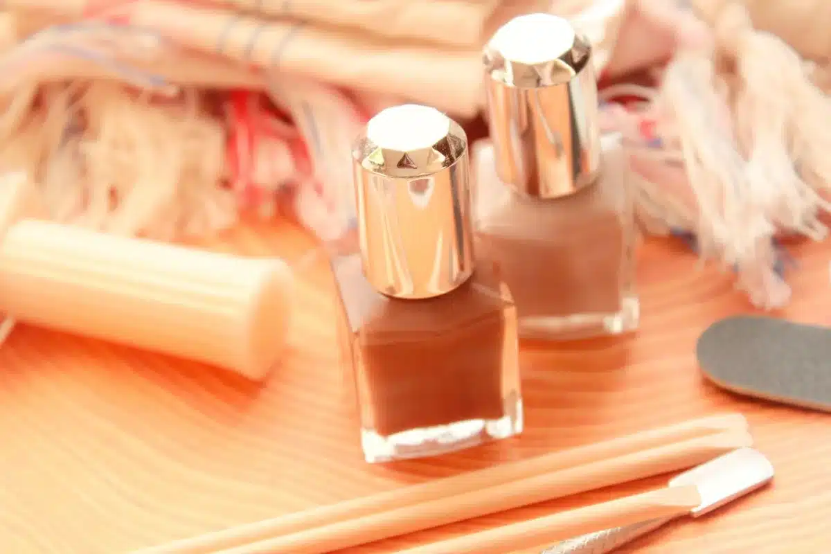 Attrezzi per manicure e mani che applicano smalto in strati sottili