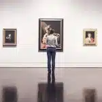Mani che reggono un paio di occhiali smart esposti in una galleria d'arte