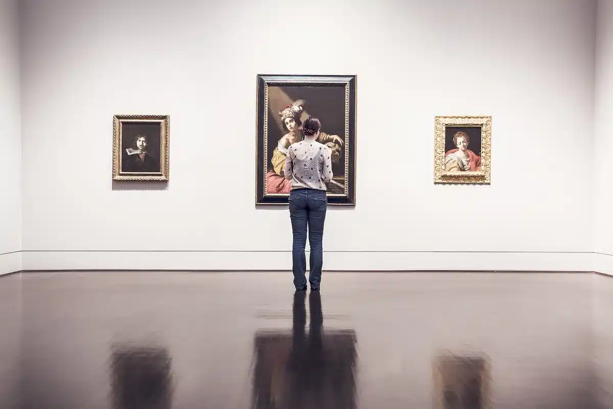 Mani che reggono un paio di occhiali smart esposti in una galleria d'arte