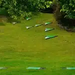 Coppa del torneo su un tavolo con mazze da golf e prato del circolo