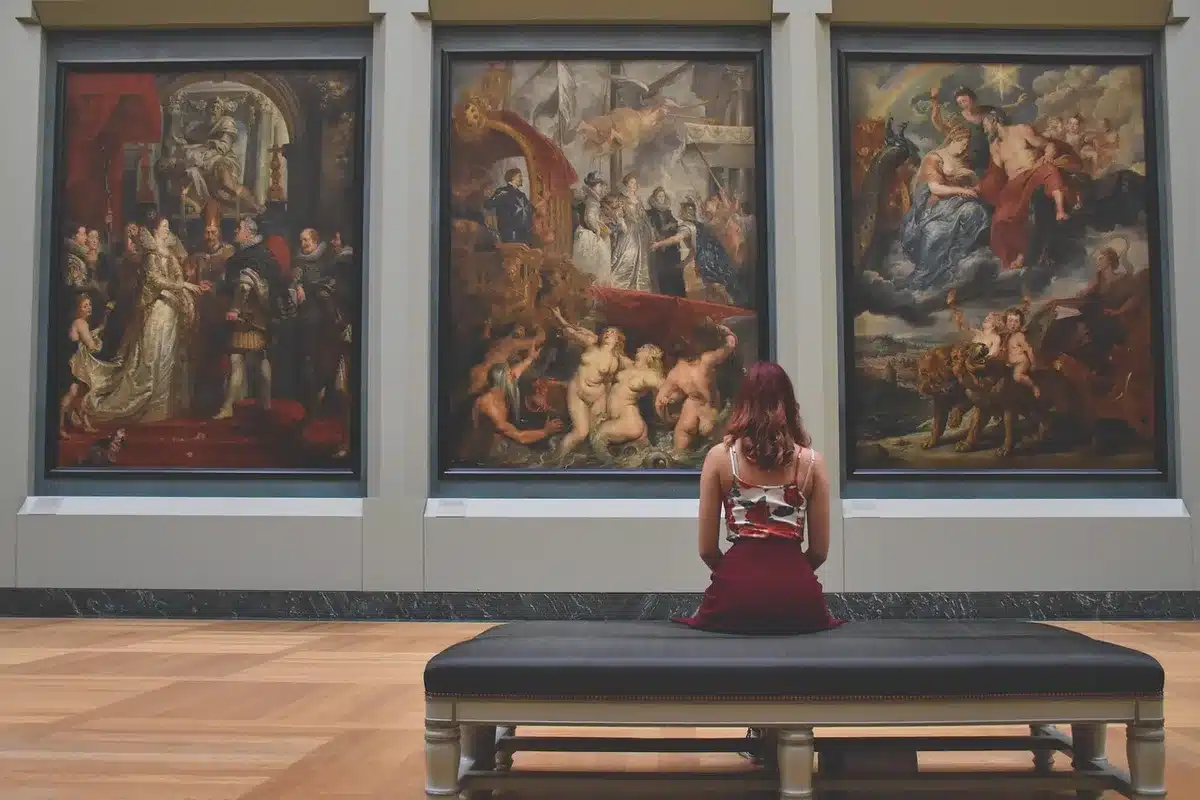 Ingresso di un locale adattato a galleria con opere esposte su pareti e tavoli