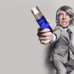 Mani anonime che tengono un contagocce e un barattolo di siero sulla toeletta