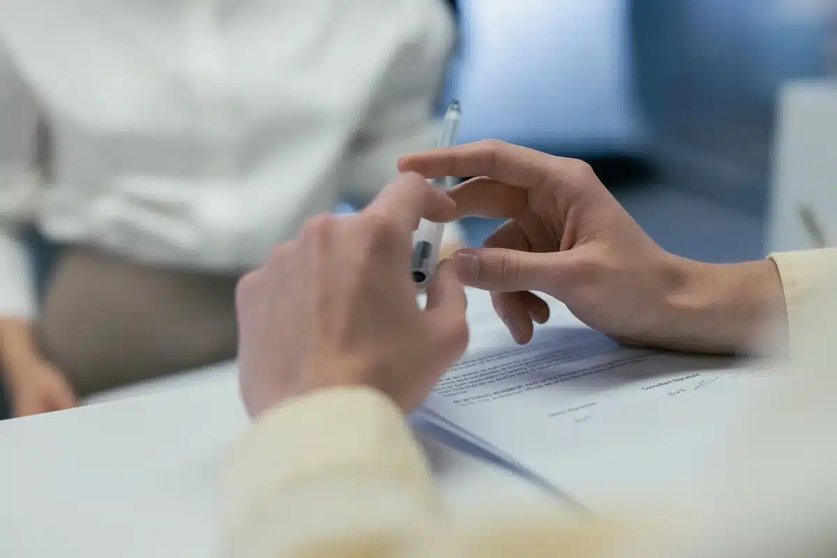 Lettera di dimissioni appoggiata su un tavolo, mani visibili