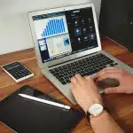 Studenti anonimi in laboratorio digitale con laptop e quaderni