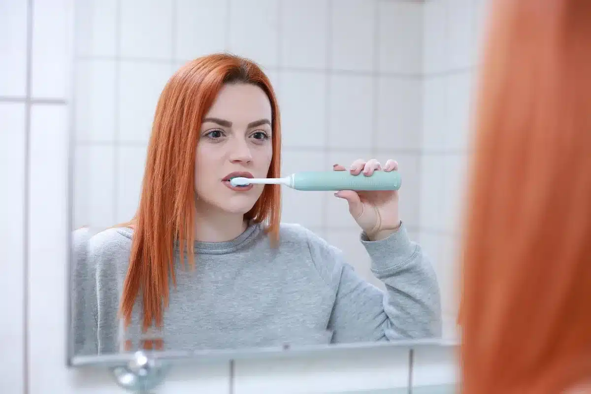 Giovane davanti al lavabo con prodotti per la pulizia e protezione solare