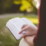Mani di adolescenti con prodotti per la pelle e un libro illustrato sul tavolo