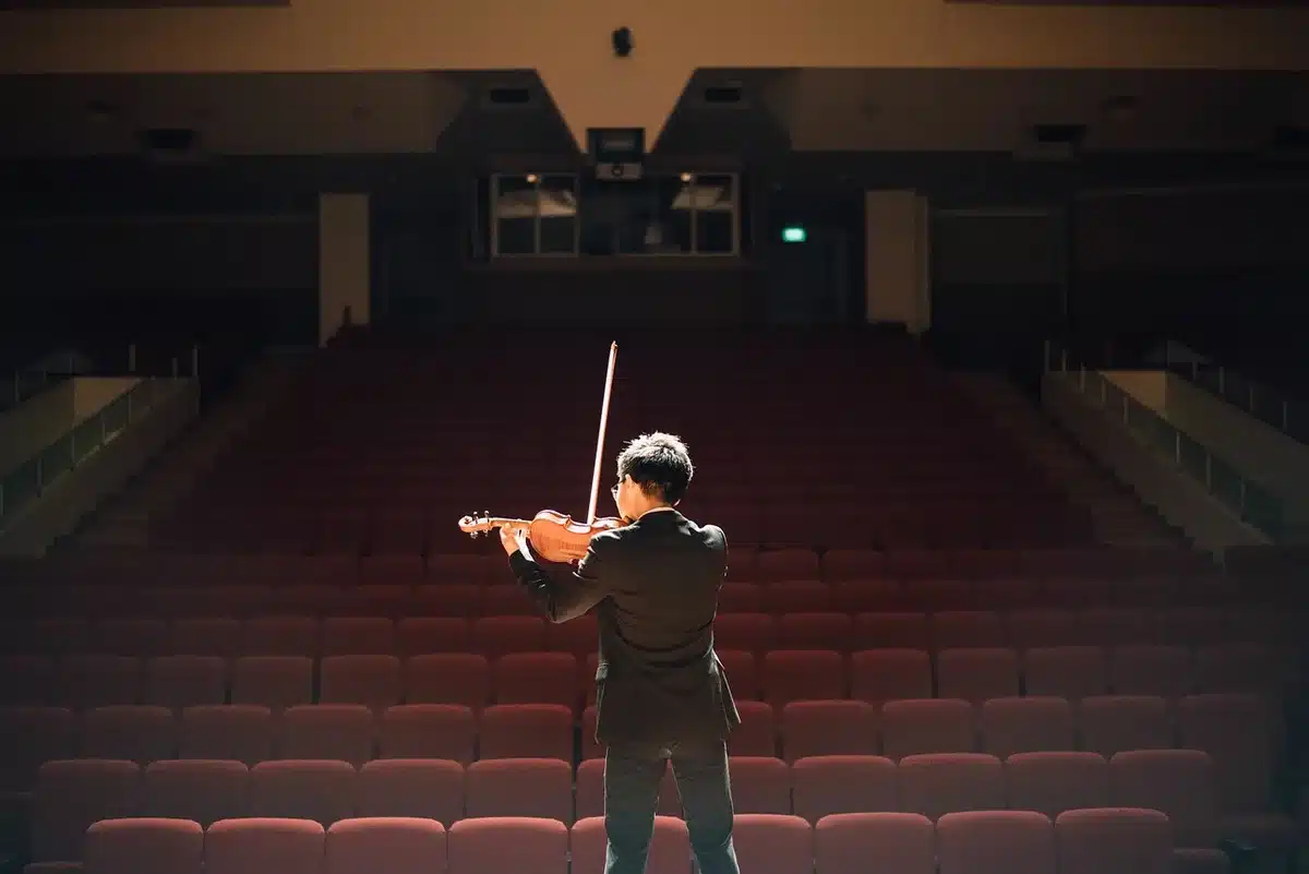 Due musicisti sul palco in controluce con chitarra e microfono