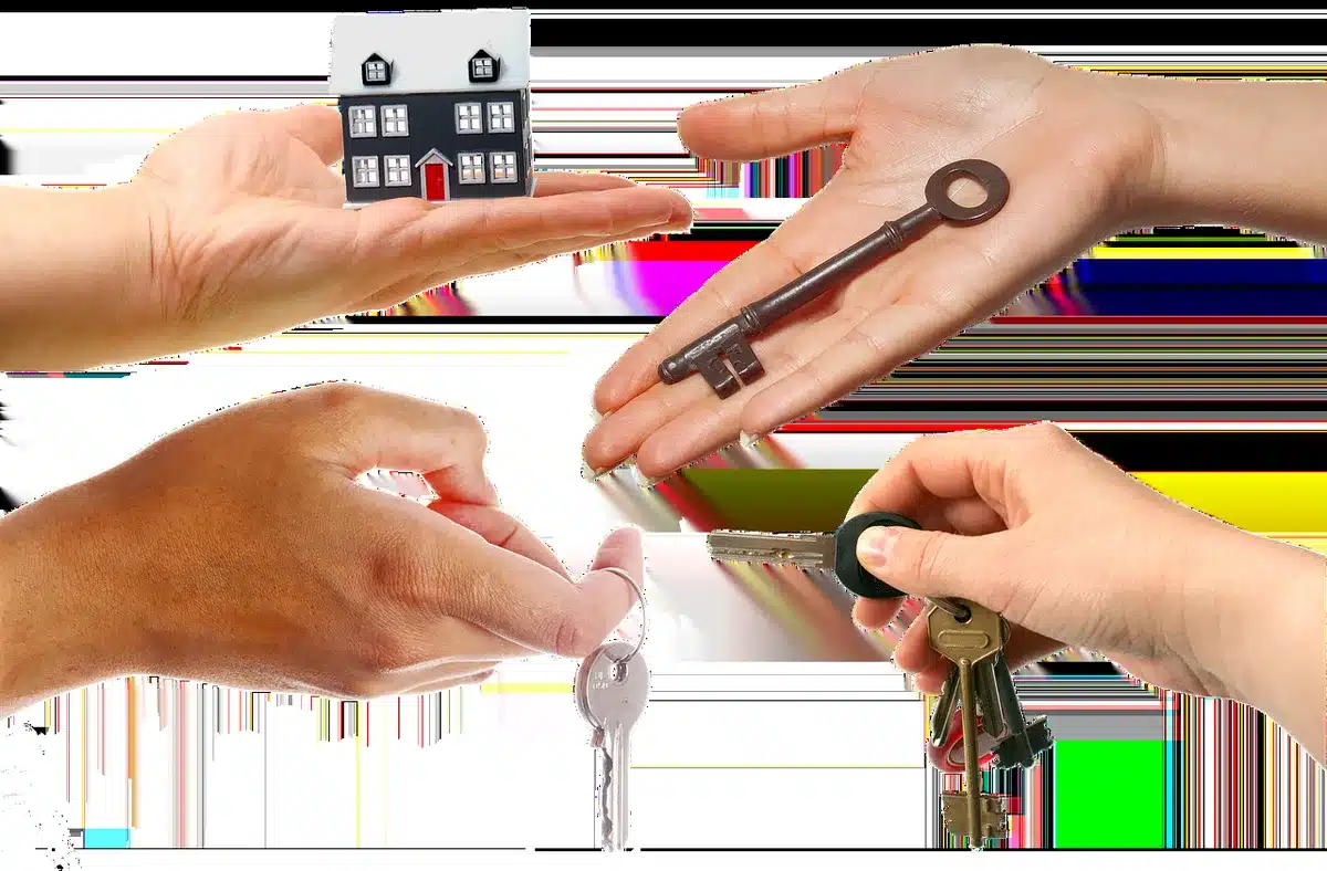 Mani anonime che usano un'app di gestione affitti con chiavi e documenti su tavolo