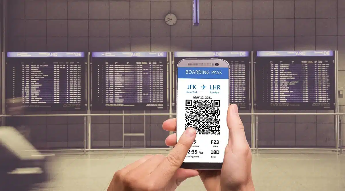 Passeggeri in coda davanti al tabellone delle partenze in aeroporto