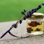 Mani anonime che applicano olio sul viso vicino a un asciugamano su un bancone