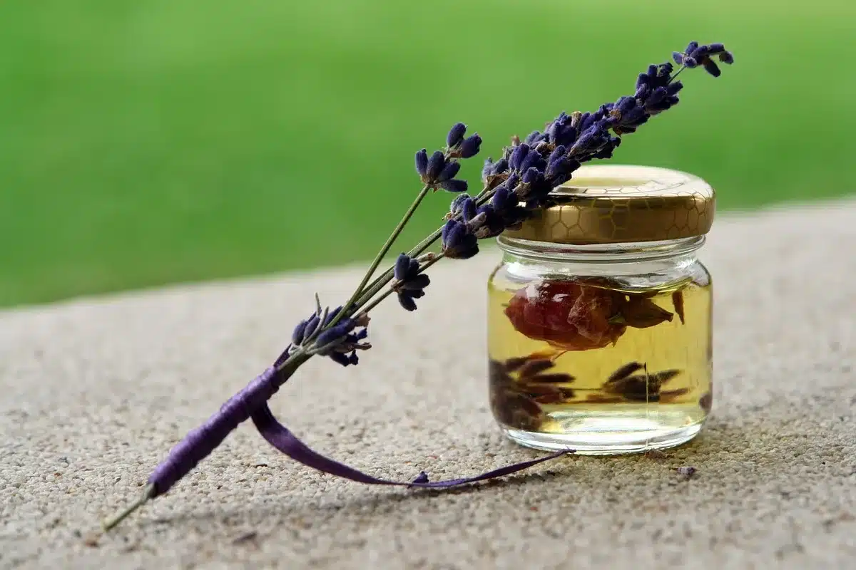Mani anonime che applicano olio sul viso vicino a un asciugamano su un bancone
